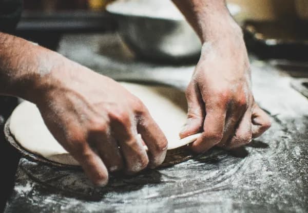 artisan étale pâte à pizza